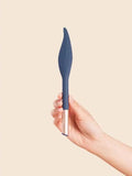 The Feather - Deia - Slim navy blue clitoral vibrator with sleek silver base held by hand ouiboutique. - clitoridien, couple, perinée, vibrateur
