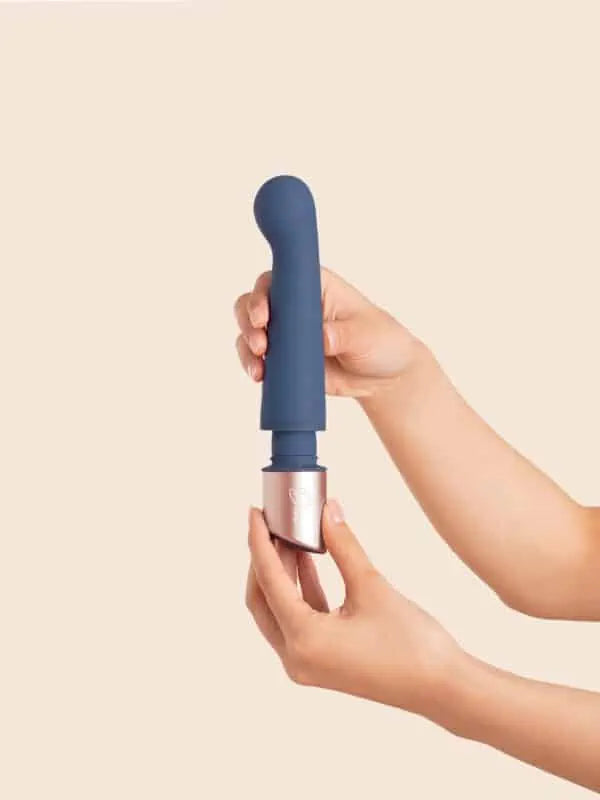 The Couple - Deia - Blue silicone dual-motor vibrator with ergonomic curves next to navy Deia packaging on peach fabric, ouiboutique. - 2 moteurs ou +, anal, clitoridien, point g, prostate, vibrateur