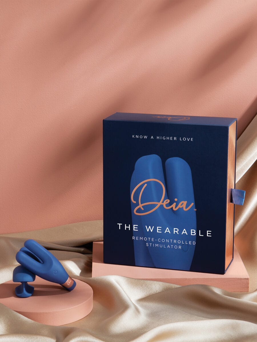 The Wearable - Compact navy blue wearable device held between hands with transparent tip, ouiboutique style.